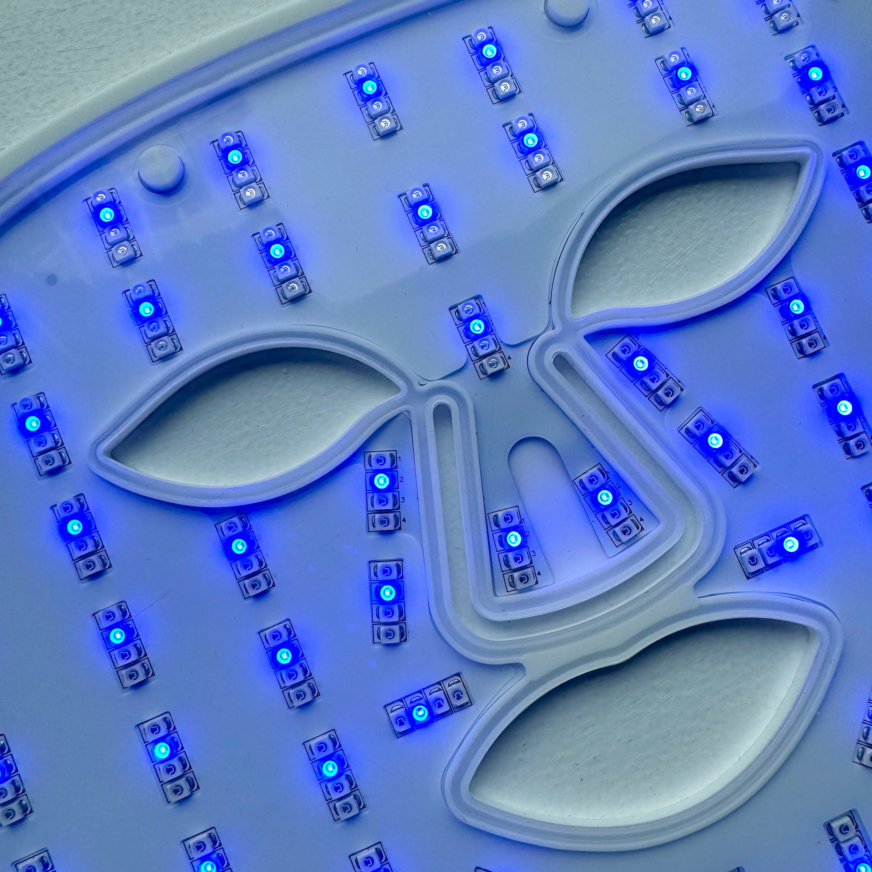 Nærbillede af LED lysterapi maske med blåt lys til behandling af akne.